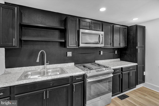 kitchen featuring stainless steel appliances, light hardwood / wood-style floors, and sink