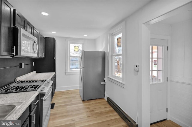 kitchen featuring sink, light hardwood / wood-style flooring, light stone countertops, and appliances with stainless steel finishes