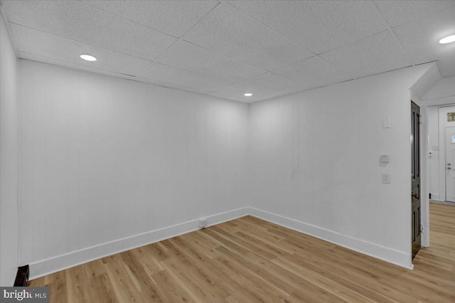 unfurnished room featuring a drop ceiling and light hardwood / wood-style flooring