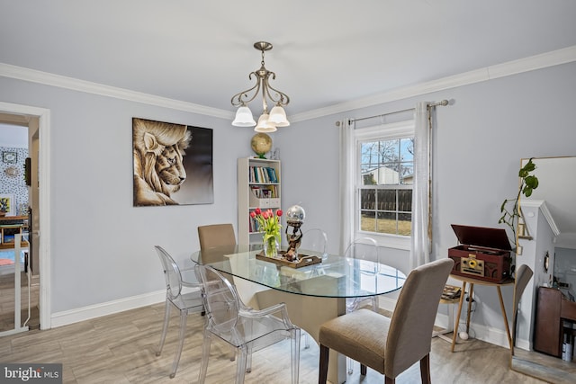 dining area with light wood-style floors, baseboards, and crown molding