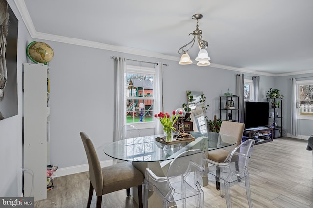 dining area with ornamental molding, plenty of natural light, and light wood-style floors