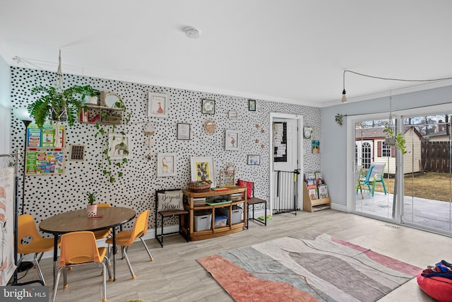 rec room with ornamental molding, visible vents, and baseboards