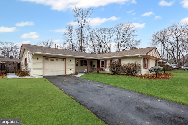 ranch-style house featuring a front yard, driveway, an attached garage, and fence