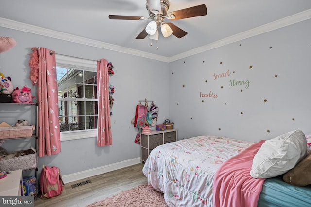 bedroom featuring ornamental molding, light wood-type flooring, visible vents, and baseboards