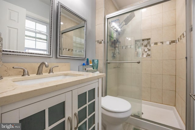 full bathroom with a stall shower, vanity, and toilet