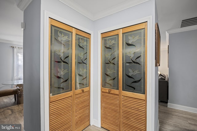 entryway with visible vents, baseboards, and crown molding