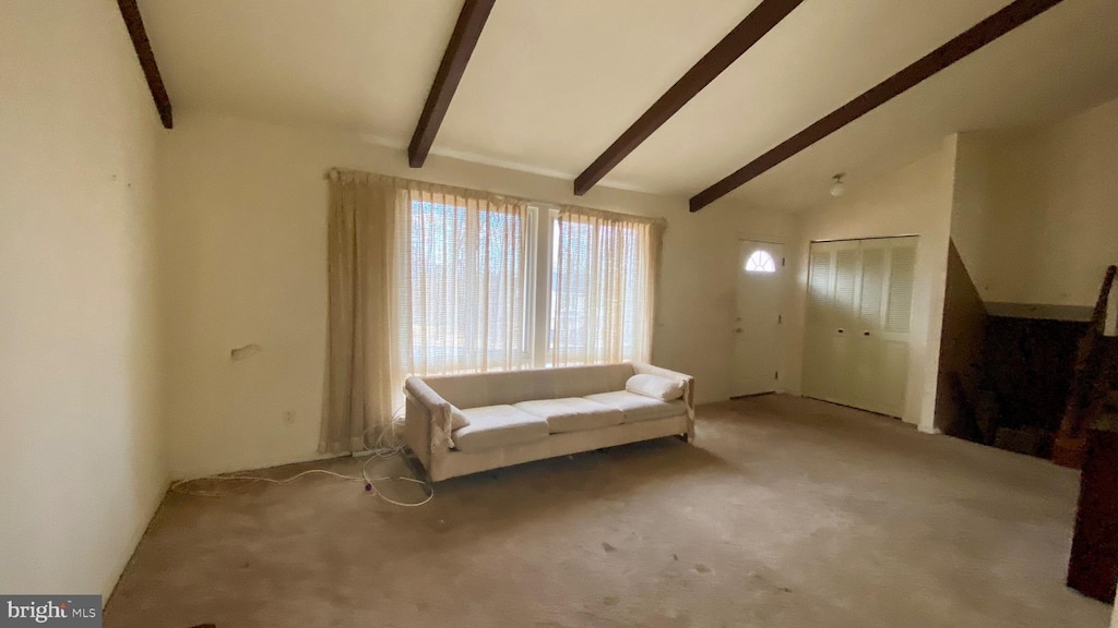 unfurnished room featuring beam ceiling, high vaulted ceiling, and light carpet