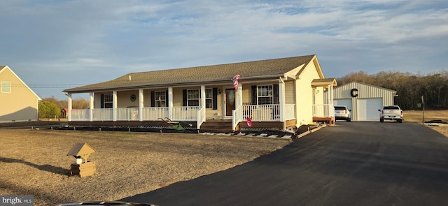 view of front of property featuring an outbuilding, a garage, and covered porch