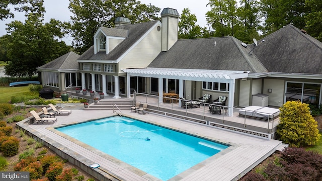26372 Westerly Rd, Easton, MD 21601 - back of property featuring a chimney, an outdoor pool, a wooden deck, a patio area, and a shingled roof