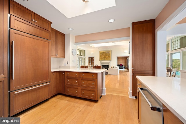 26372 Westerly Rd, Easton, MD 21601 - kitchen featuring light wood-style floors, a fireplace, light countertops, a peninsula, and open floor plan