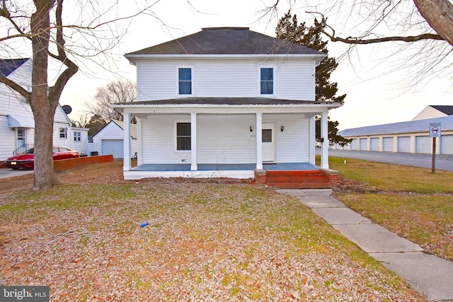 view of front of house featuring a porch, a garage, and a front yard