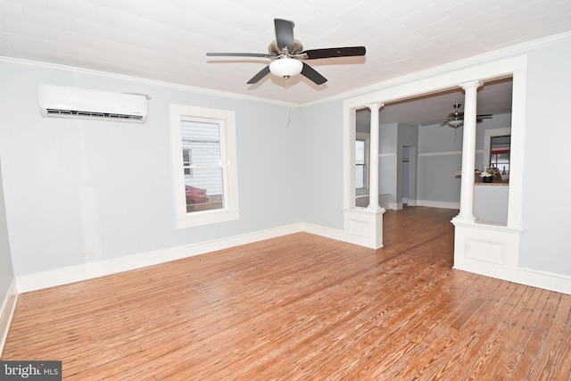 spare room with light hardwood / wood-style floors, ornamental molding, decorative columns, and an AC wall unit