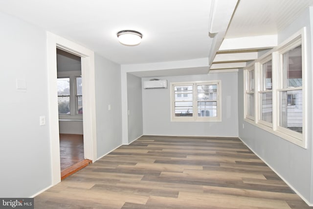 hallway featuring a wealth of natural light, dark wood-type flooring, and a wall mounted AC