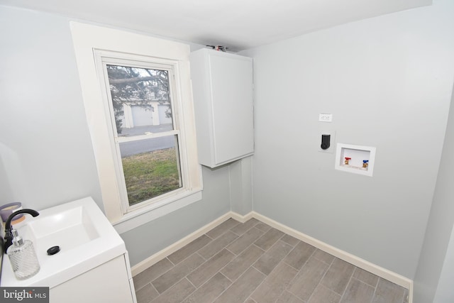 clothes washing area with cabinets, washer hookup, hookup for an electric dryer, and sink