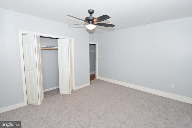 unfurnished bedroom featuring light carpet, ceiling fan, and a closet