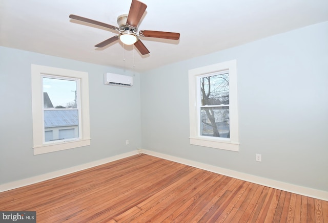 unfurnished room featuring ceiling fan, hardwood / wood-style flooring, and a wall mounted AC