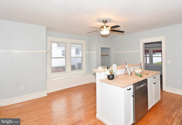 kitchen with white cabinetry, an island with sink, stainless steel dishwasher, ceiling fan, and light hardwood / wood-style flooring