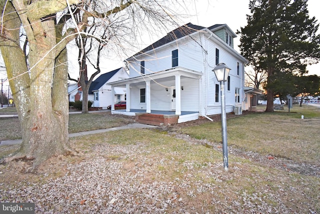 view of front of home with a porch, central AC unit, and a front lawn