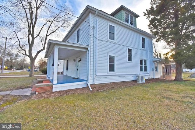 view of side of home featuring a porch and a yard