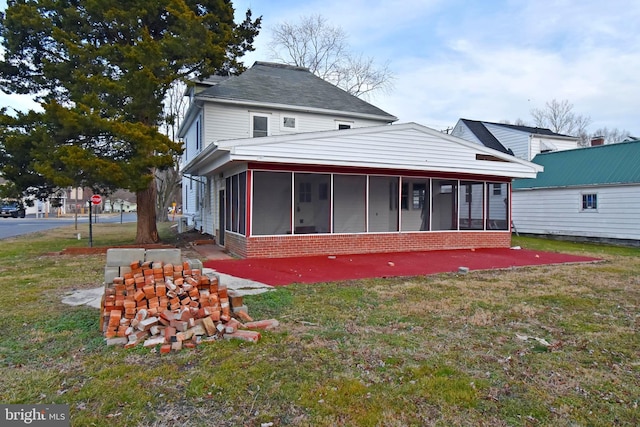 back of house with a lawn and a sunroom