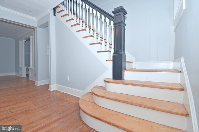 stairs featuring ornamental molding and hardwood / wood-style floors