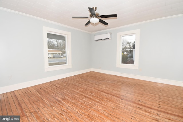 empty room with crown molding, a healthy amount of sunlight, a wall mounted AC, and light hardwood / wood-style floors