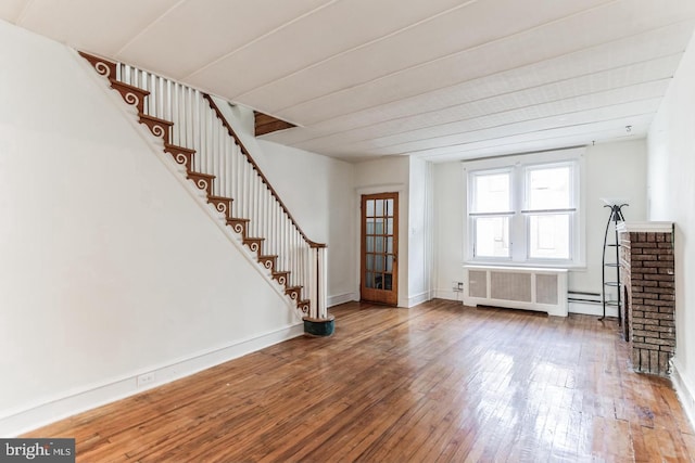 unfurnished living room featuring radiator and hardwood / wood-style floors