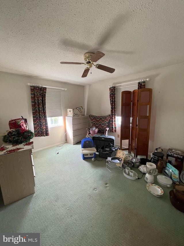 interior space with ceiling fan and a textured ceiling