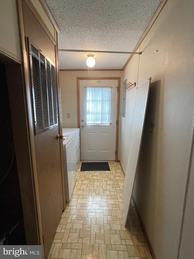 doorway to outside with washing machine and clothes dryer, crown molding, and a textured ceiling