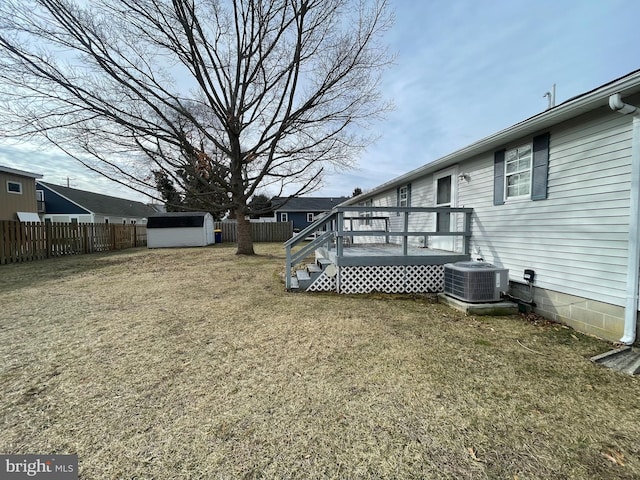 view of yard with a shed, central AC unit, and a wooden deck