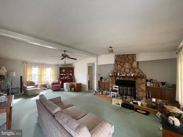 carpeted living room with ceiling fan, lofted ceiling with beams, a textured ceiling, and a fireplace