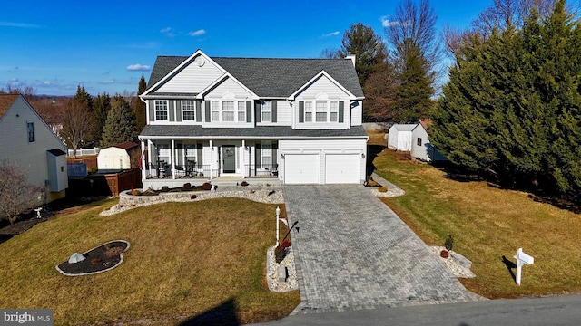 view of front property featuring a garage, a front yard, and covered porch