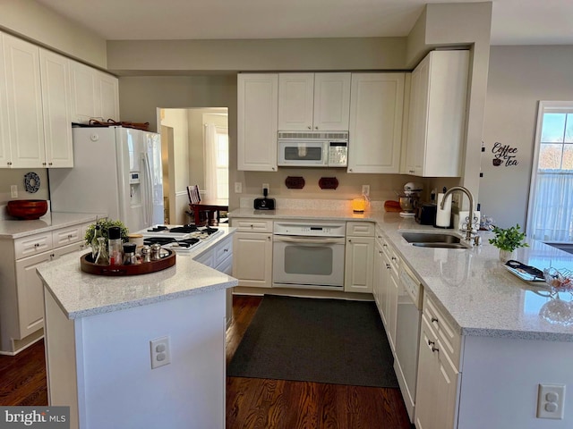 kitchen with white cabinetry, white appliances, sink, and light stone counters