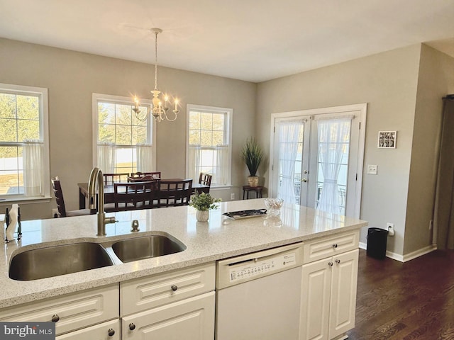 kitchen with sink, decorative light fixtures, dark hardwood / wood-style floors, white dishwasher, and light stone countertops