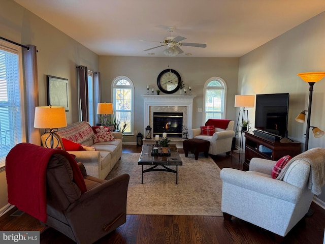 living room with ceiling fan, a high end fireplace, and dark hardwood / wood-style flooring