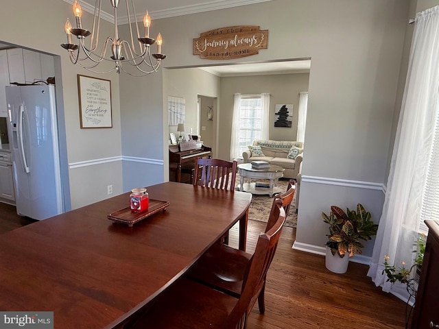 dining area featuring crown molding, an inviting chandelier, and dark hardwood / wood-style flooring