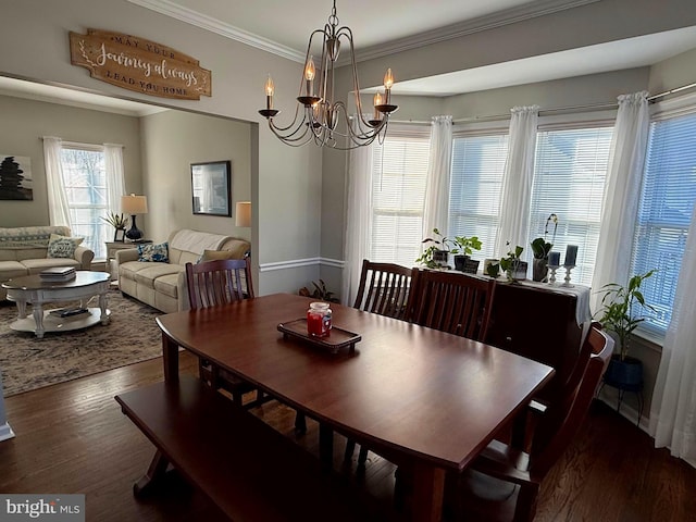 dining area featuring an inviting chandelier, crown molding, and dark wood-type flooring