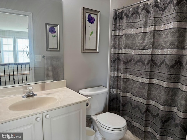 bathroom featuring vanity, curtained shower, and toilet