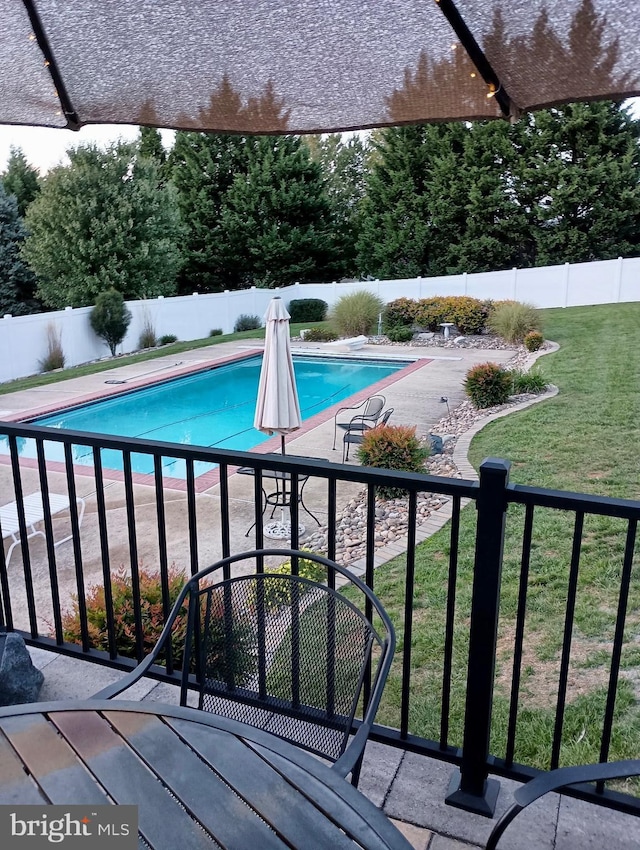 view of pool with a lawn