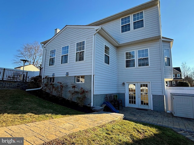 back of property featuring a patio, a yard, and french doors