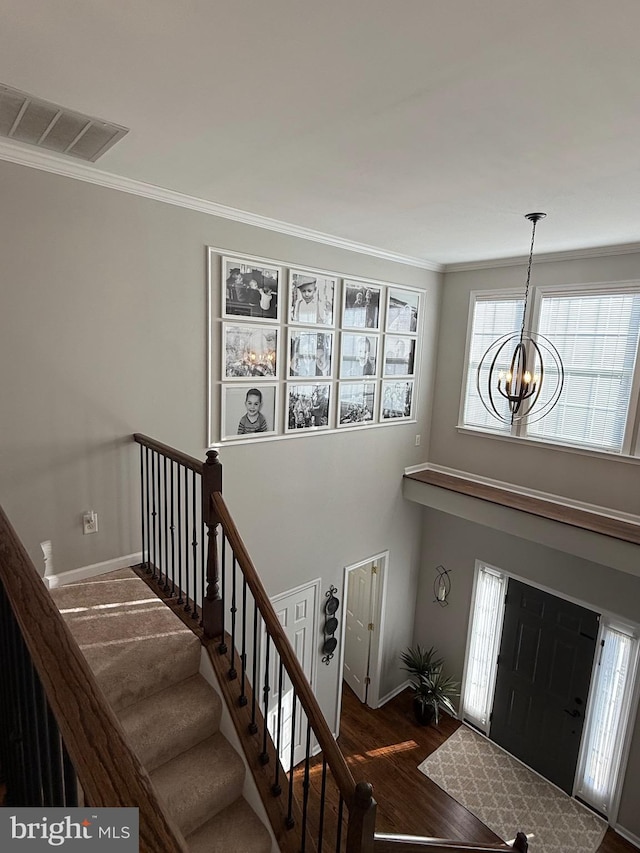 entryway featuring crown molding, dark hardwood / wood-style flooring, and a notable chandelier