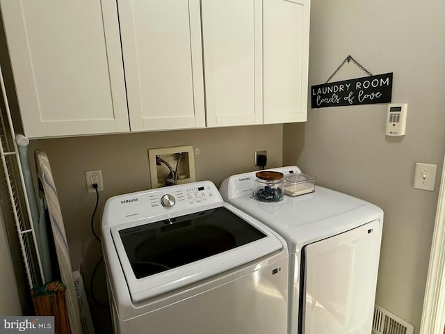 clothes washing area featuring washing machine and dryer and cabinets