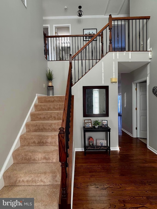 stairs featuring crown molding and hardwood / wood-style flooring