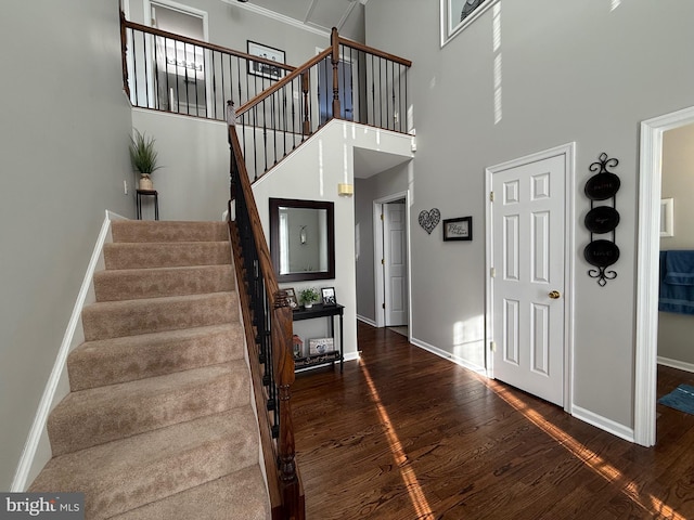 stairway featuring hardwood / wood-style floors and a high ceiling