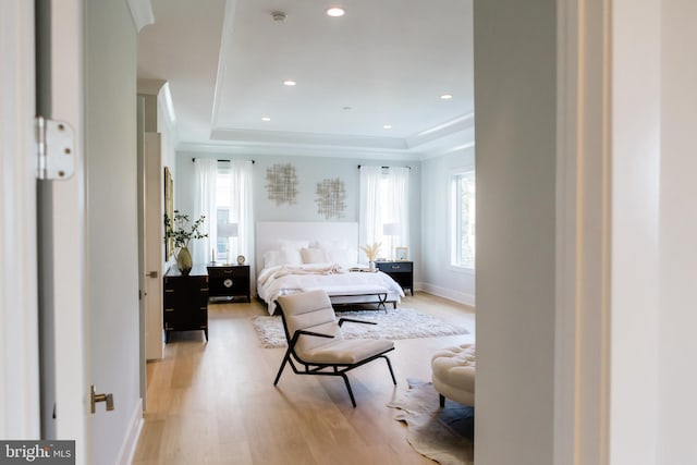 bedroom with recessed lighting, baseboards, a raised ceiling, and light wood-style flooring