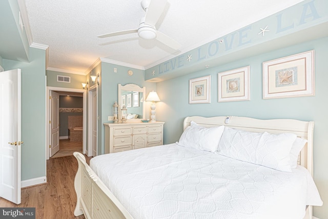 bedroom with ceiling fan, crown molding, light hardwood / wood-style flooring, and a textured ceiling