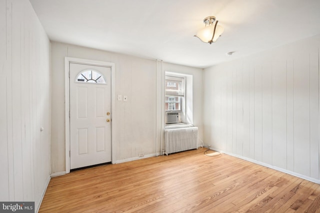 foyer with radiator, cooling unit, and light hardwood / wood-style flooring