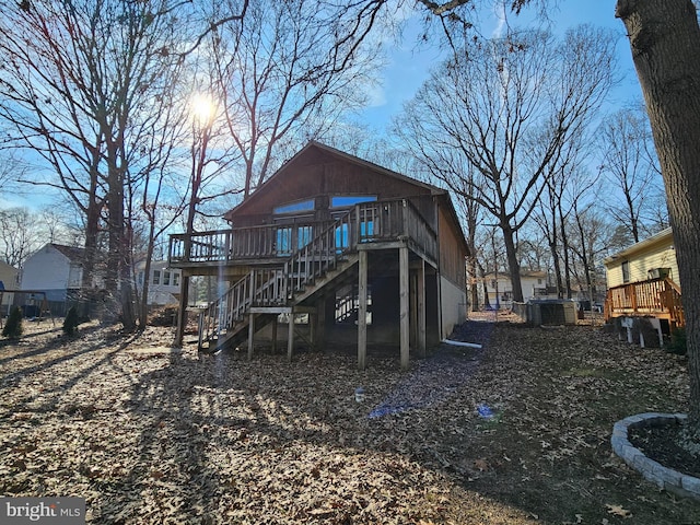 rear view of property with stairs and a deck