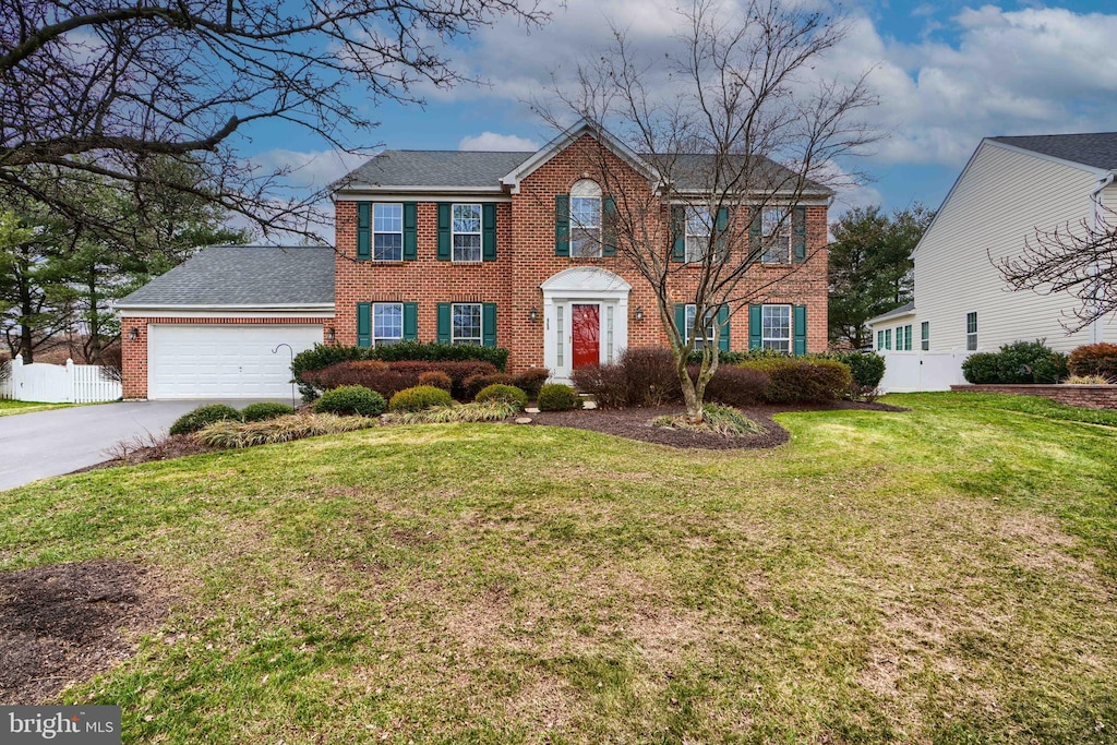 colonial home with a garage and a front yard