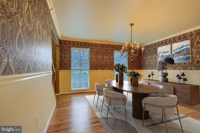 dining space with crown molding, a chandelier, and light wood-type flooring